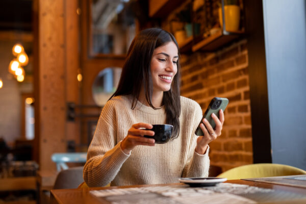 Young woman sitting in cafeteria, enjoying morning coffee